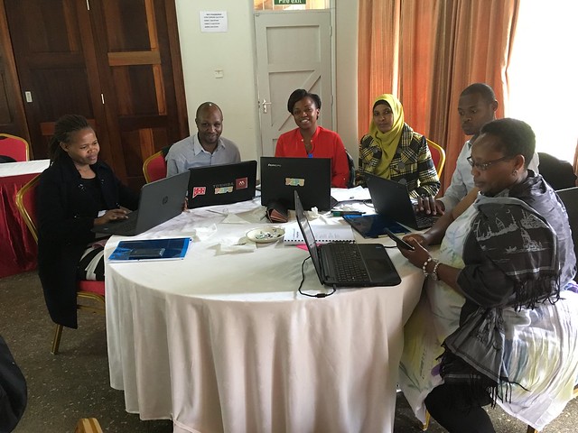 Here is a picture of a group of kenya librarians sitting in circle using computers